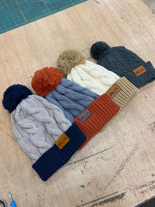 pom pom cable knit beanie with leather lasered tag